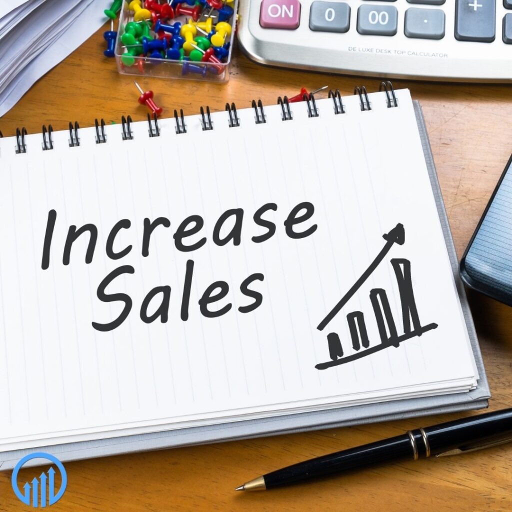 notebook on a desk with "increase sales" and an upward trending sales graph written on it