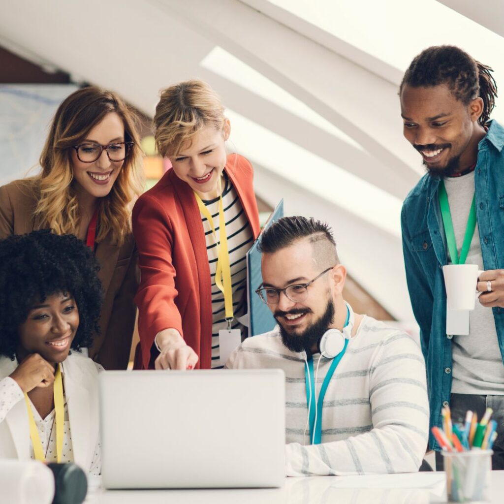 diverse team collaborating around a laptop