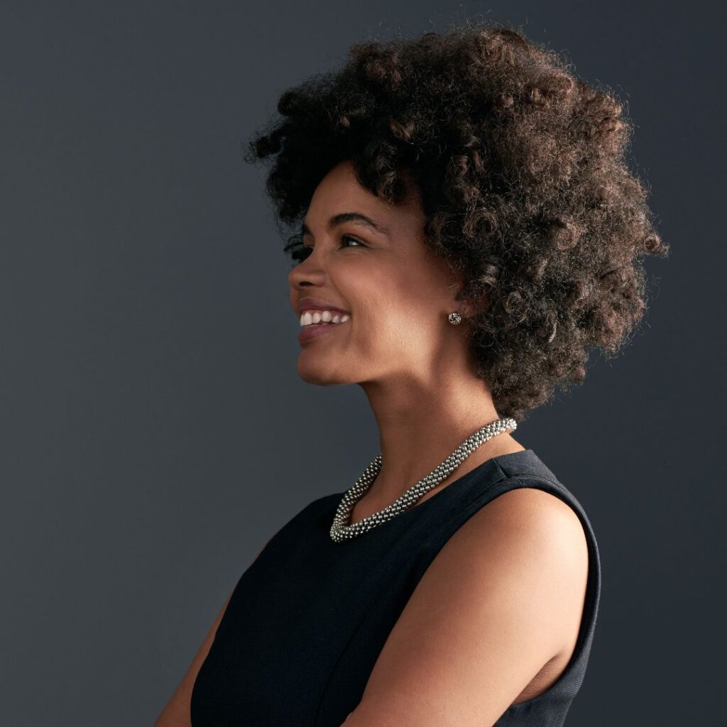 confident, professional African American woman against a gray backdrop, smiling
