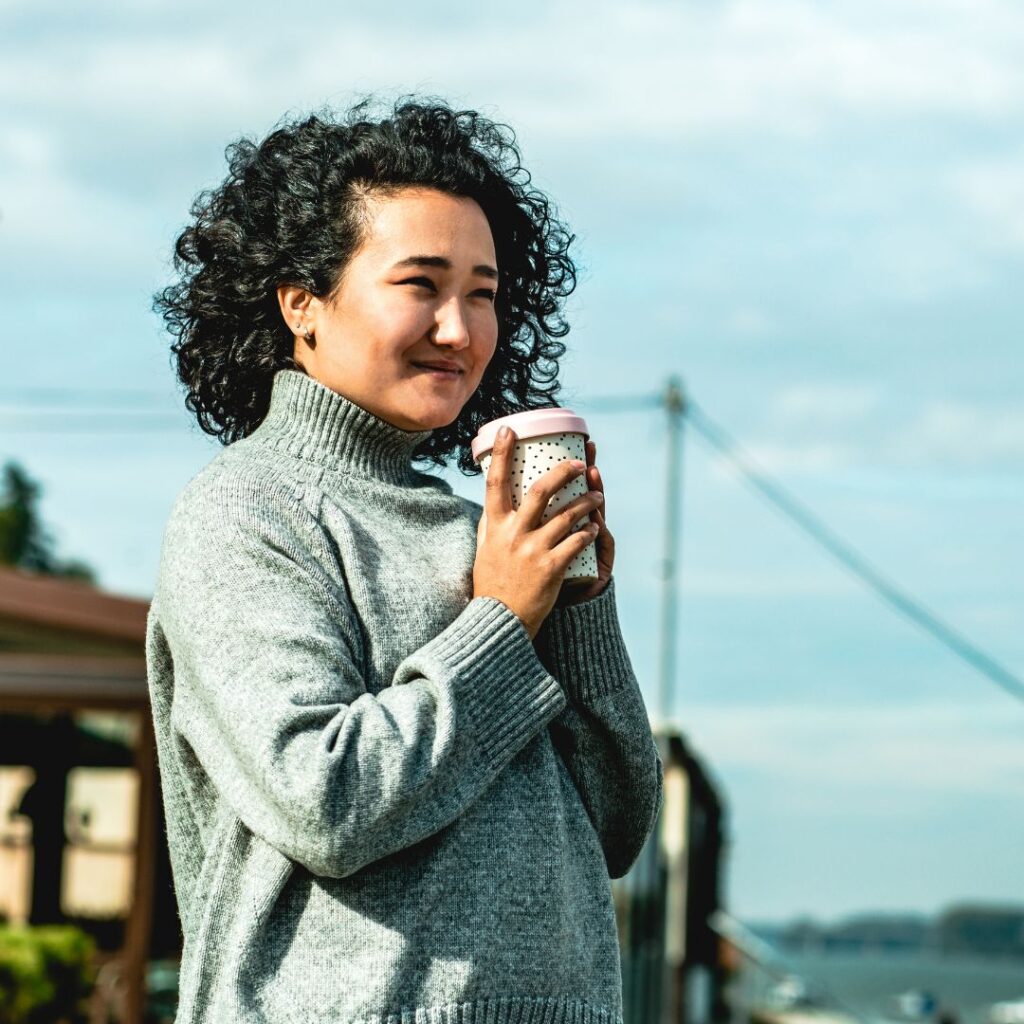 smiling professional woman holding a cup of coffee