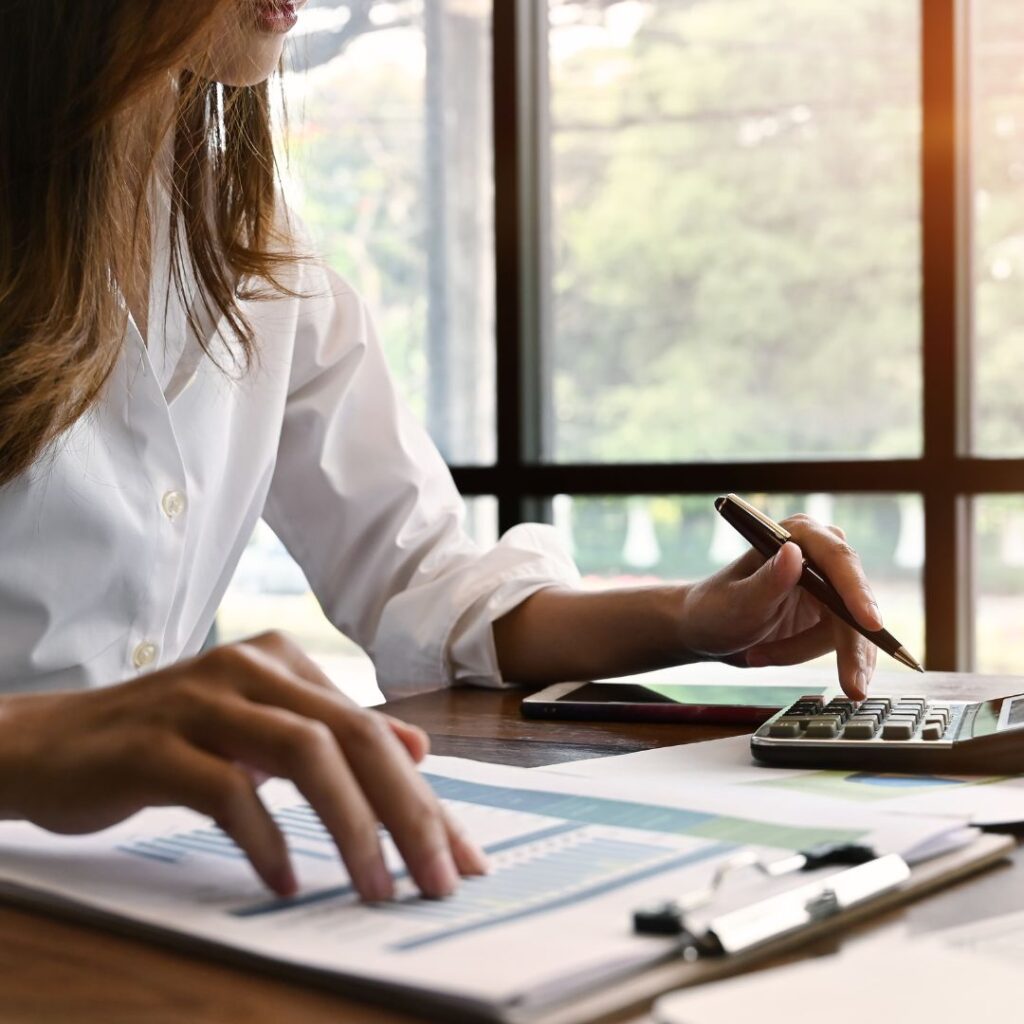 woman in a white shirt working on financial documents