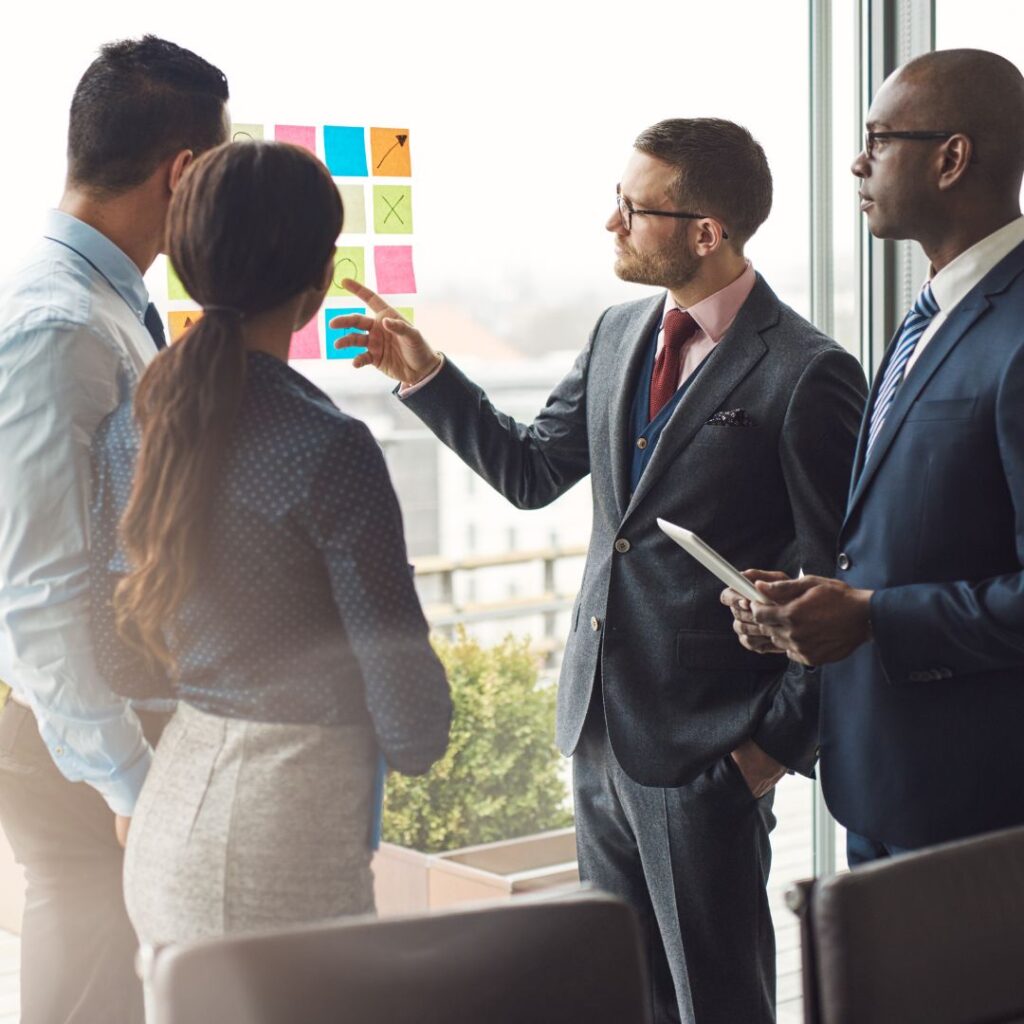 group of professionals working around a project board